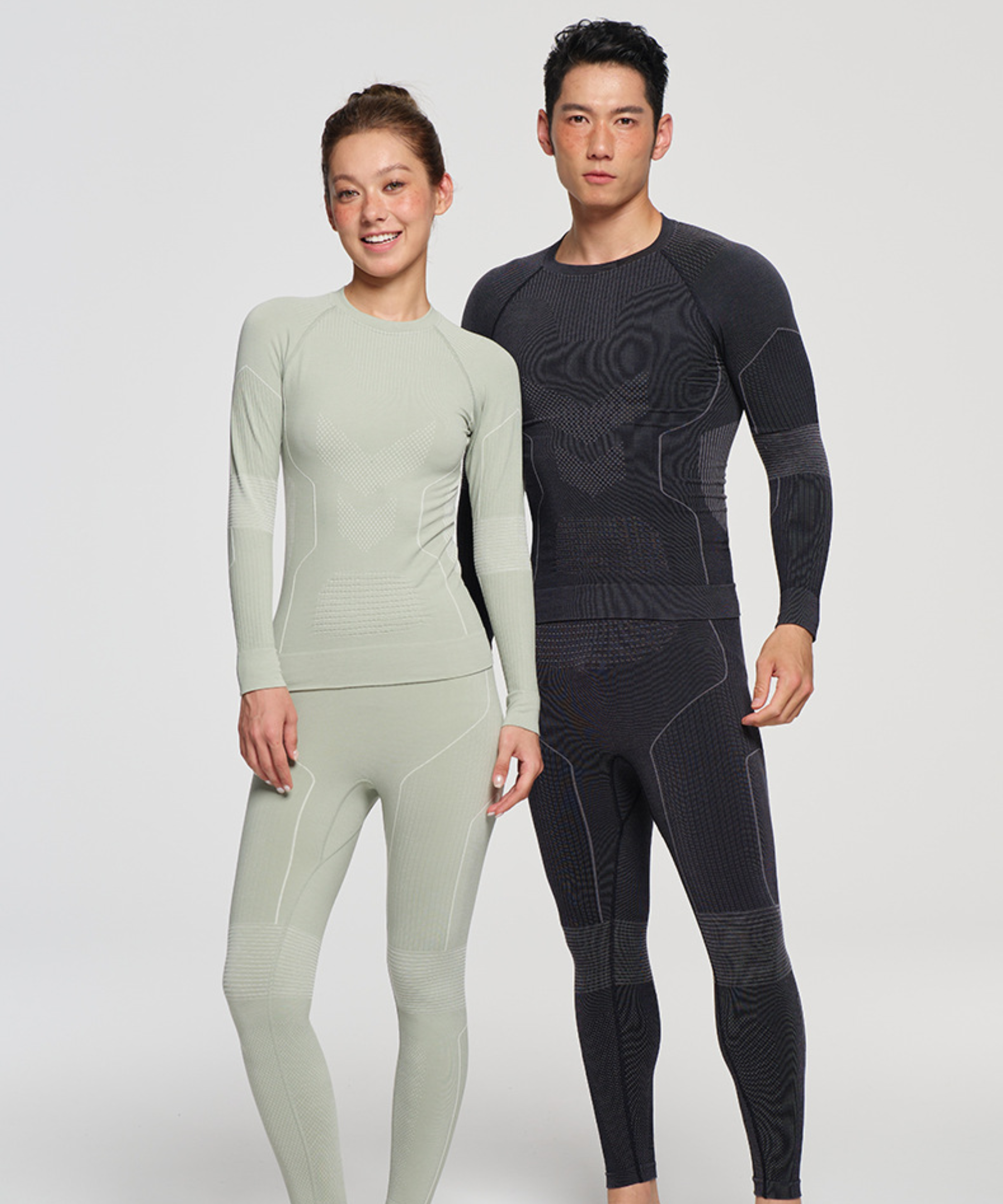 Two people wearing full-body compression suits on a white background